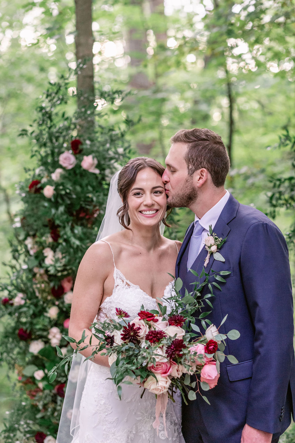 Bride and groom with lush ceremony florals